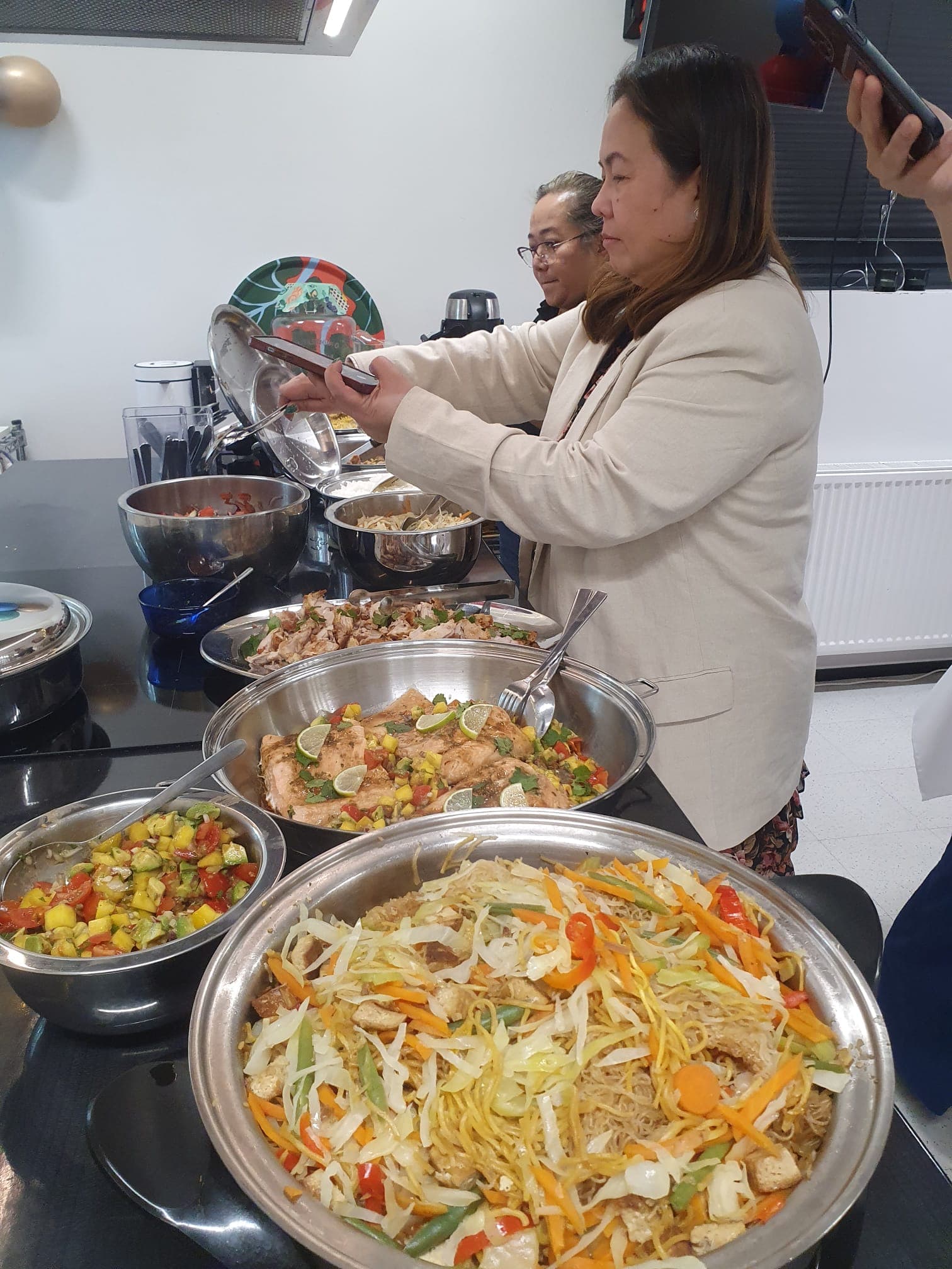 Guests serving from a buffet of freshly cooked dishes at a demo